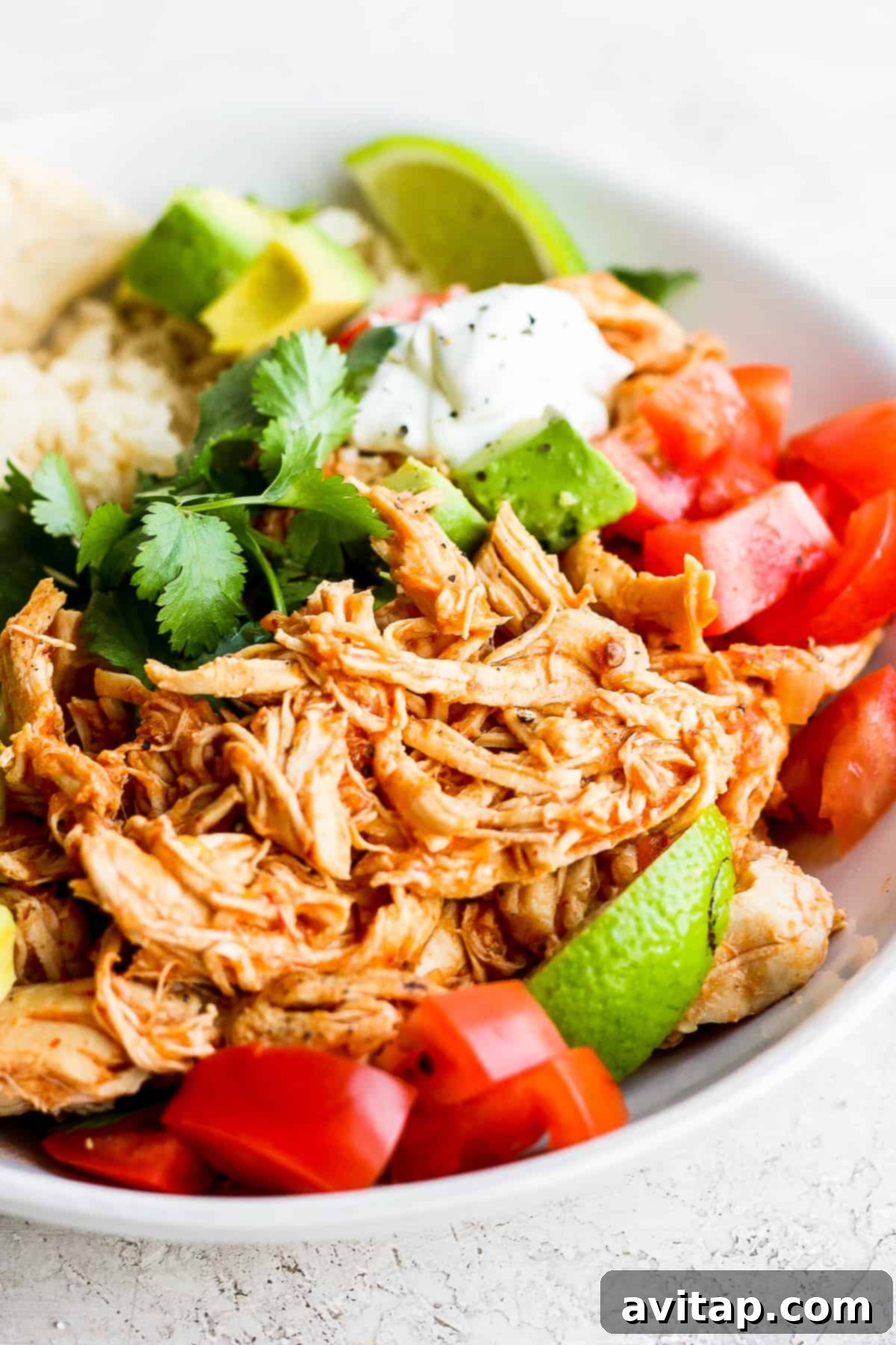 A fresh bowl of chicken tinga, garnished with cilantro and avocado, ready to be enjoyed.