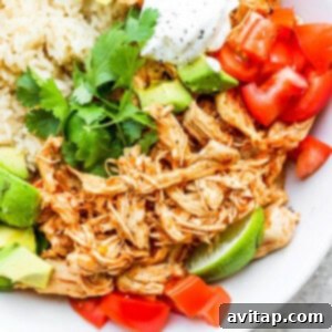 Mexican chicken rice bowl with avocado, tomatoes and sour cream.