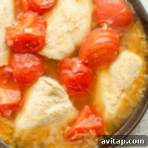 Chicken and tomatoes in a skillet.