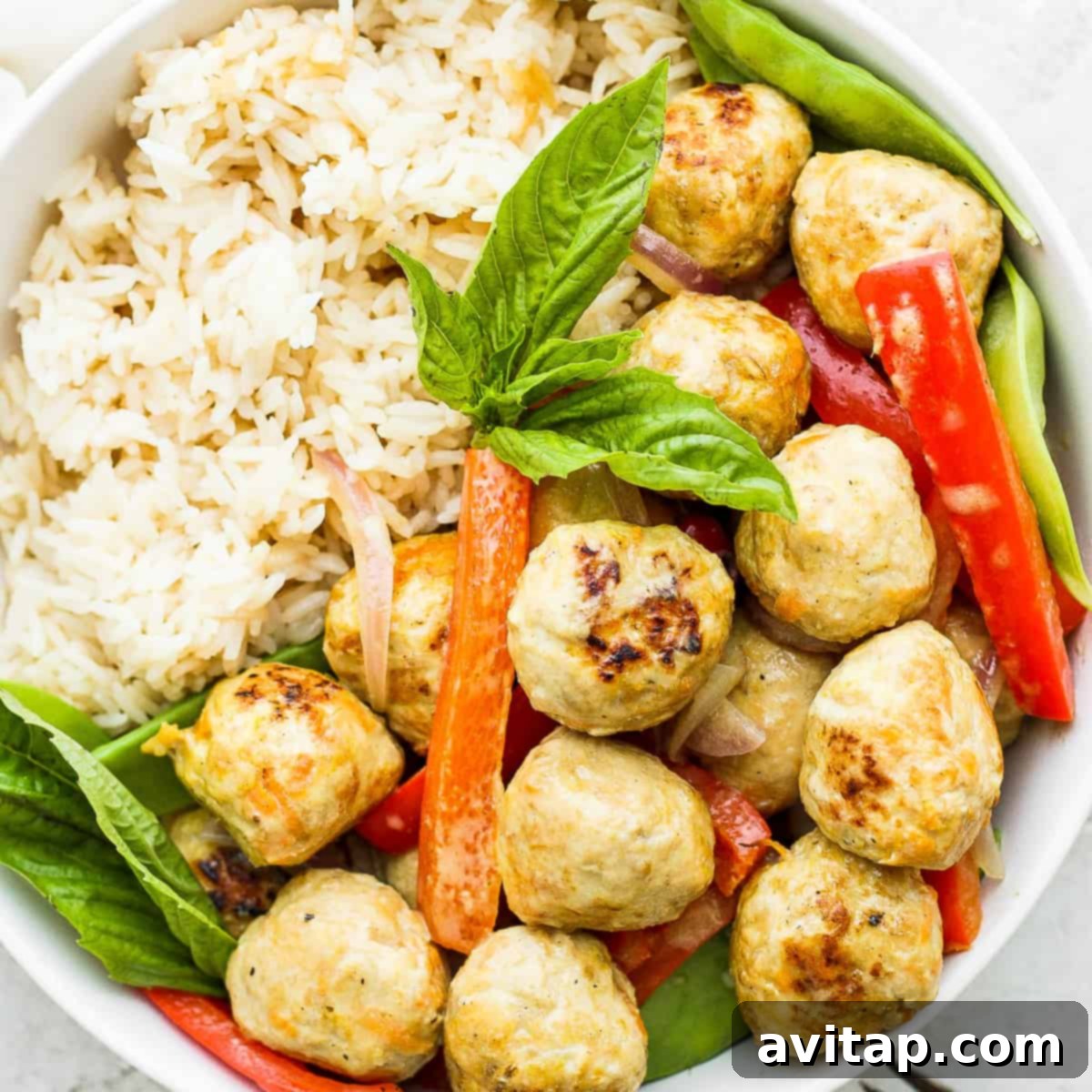 Vibrant Green Curry Chicken Meatballs 8 A beautifully plated bowl of green curry chicken meatballs with colorful vegetables and fluffy rice, ready to be enjoyed as a healthy and satisfying meal.