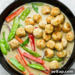 Vibrant Green Curry Chicken Meatballs 9 Adding the browned chicken meatballs to the vibrant veggies and green curry sauce in a skillet, ready for simmering.