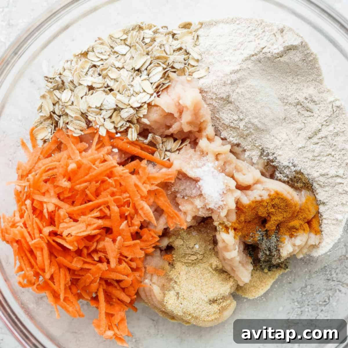 Vibrant Green Curry Chicken Meatballs 3 All the fresh ingredients for homemade green curry chicken meatballs in a mixing bowl, including ground chicken, shredded sweet potato, oats, flour, and aromatic spices, ready to be combined.