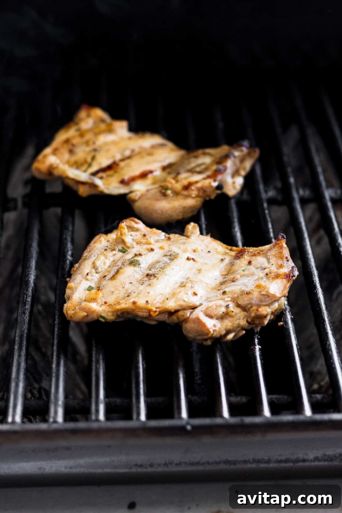 boneless skinless chicken thighs on grill grates.