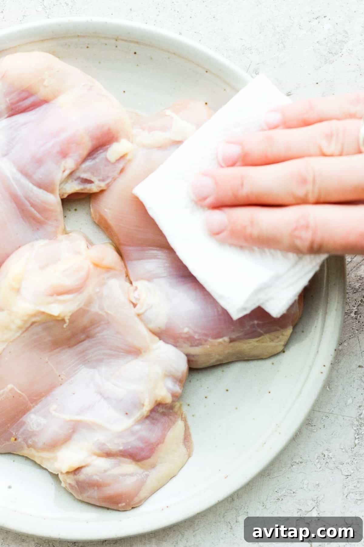 removing moisture from thighs on plate.