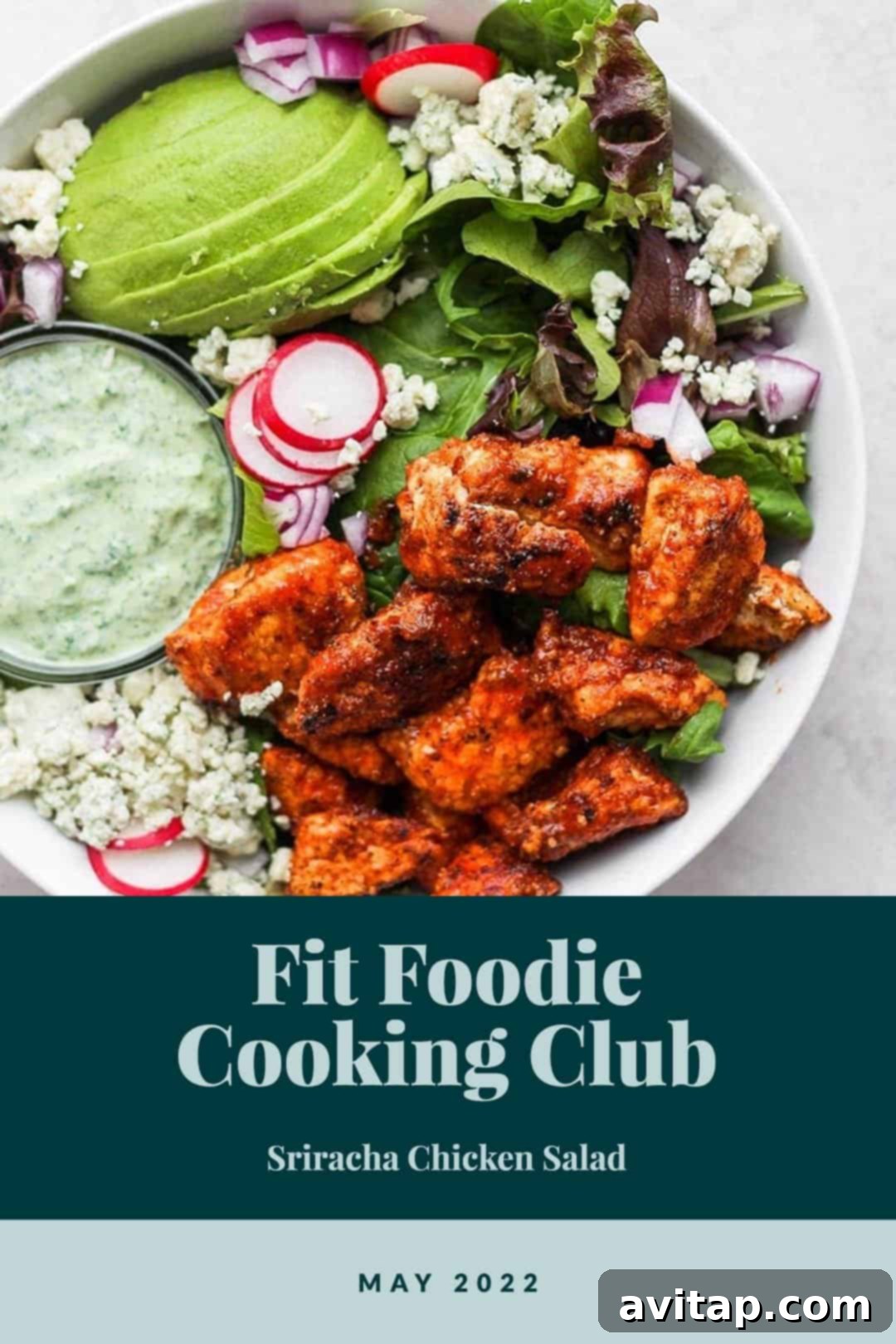 A large bowl of Sriracha Chicken Salad with crispy chicken, fresh greens, and a creamy dressing drizzled over it, garnished with avocado slices and blue cheese.