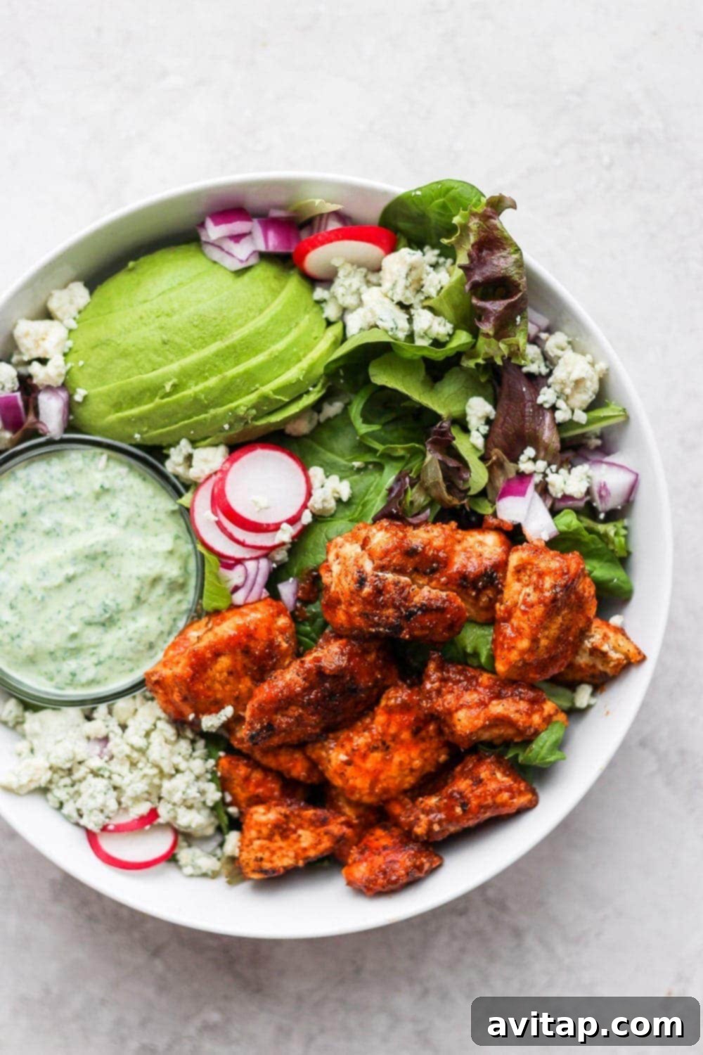 Close-up of Sriracha chicken salad in a bowl, showcasing the vibrant ingredients and crispy chicken pieces.