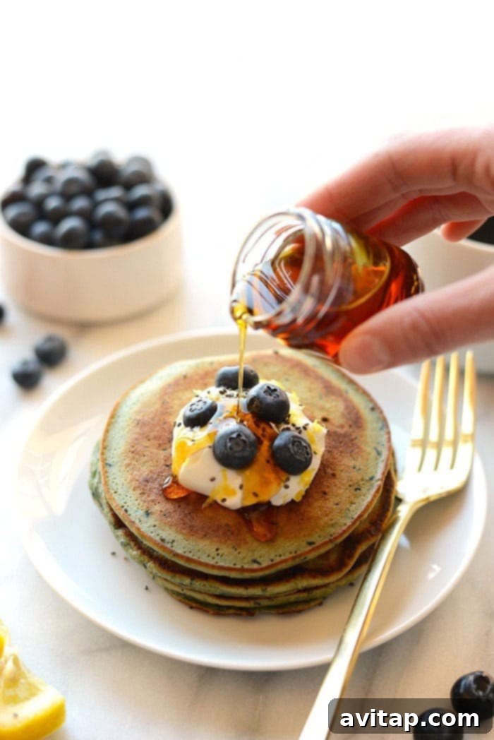 Fluffy Blender Lemon Blueberry Pancakes 2 fluffy blender lemon blueberry pancakes stacked on a plate with fresh blueberries and lemon slices