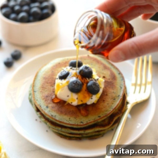 Fluffy Blender Lemon Blueberry Pancakes 3 blender lemon blueberry pancakes on a plate, garnished with fresh fruit