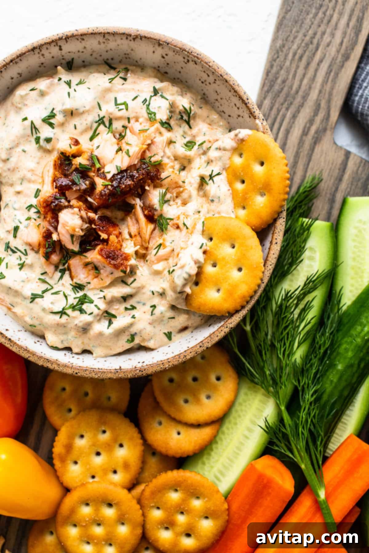 A beautifully presented bowl of creamy smoked salmon dip, garnished with fresh dill and a sprinkle of paprika.