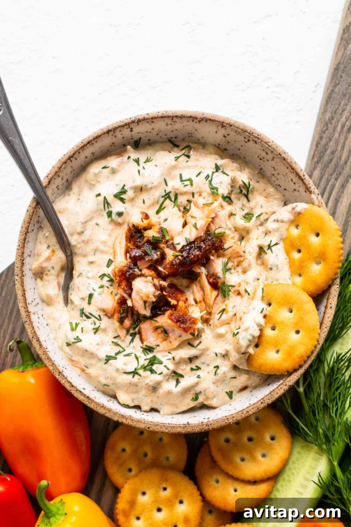 A close-up shot of creamy smoked salmon dip in a elegant white bowl, ready to be served.