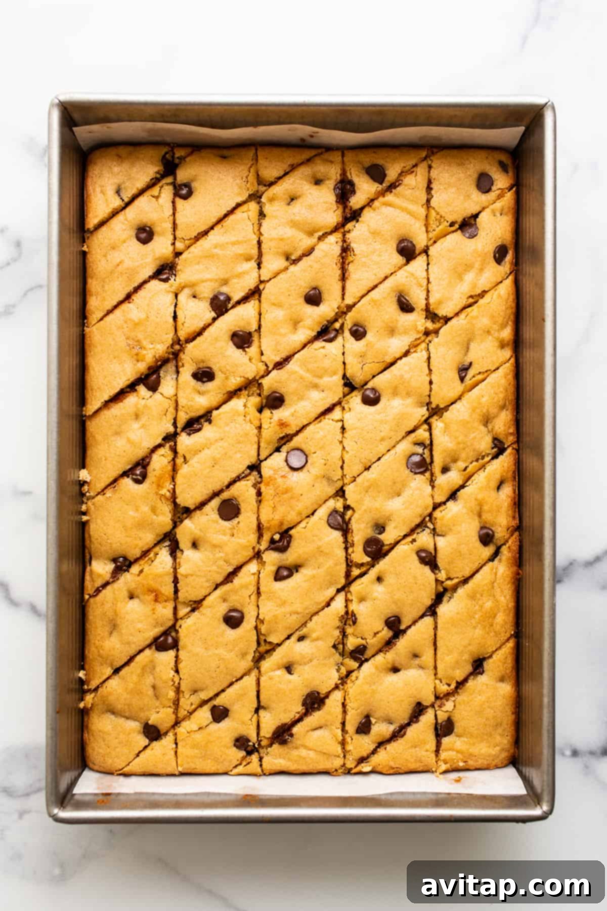 Maple-Infused Chocolate Chip Blondie Bars 7 A beautifully arranged stack of freshly baked and perfectly sliced maple chocolate chip cookie blondies on a simple white plate.