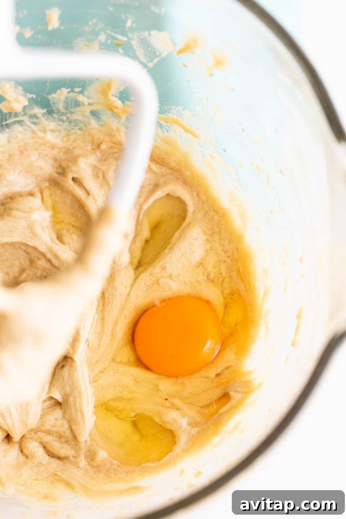 Maple-Infused Chocolate Chip Blondie Bars 3 A large mixing bowl filled with creamy blondie batter being blended with an electric hand mixer, showcasing the smooth texture.