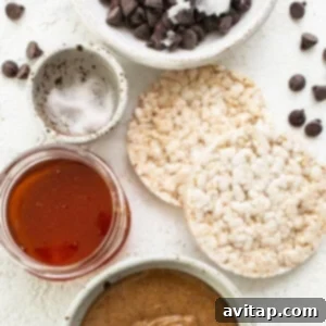 A bowl containing creamy peanut butter, chocolate chips, and other ingredients, with crumbled rice cakes visible.
