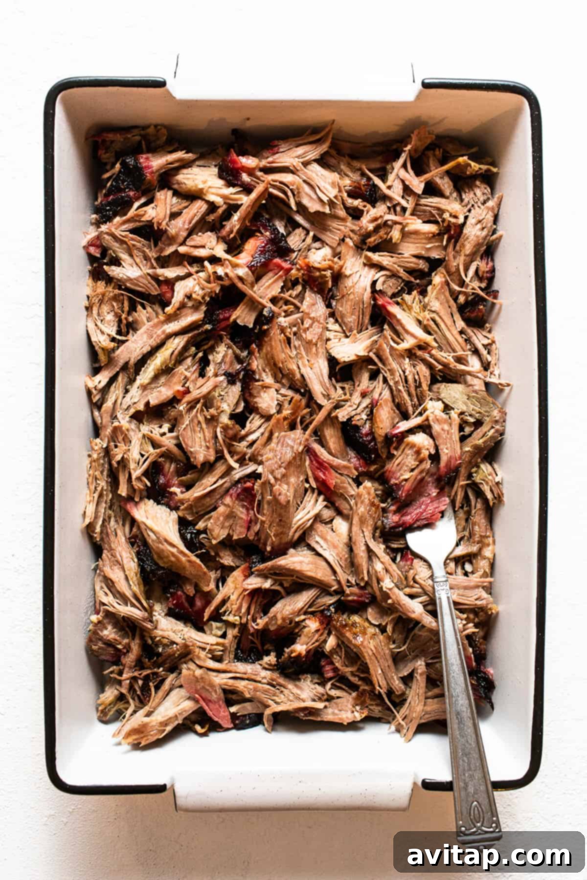 Tender Smoked Pork Shoulder 8 A large serving dish filled with perfectly shredded smoked pork shoulder, ready to be enjoyed as a main course or incorporated into various recipes.