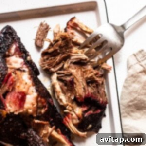 Beautifully smoked pork shoulder on a serving tray, ready to be carved or shredded for a delicious meal.