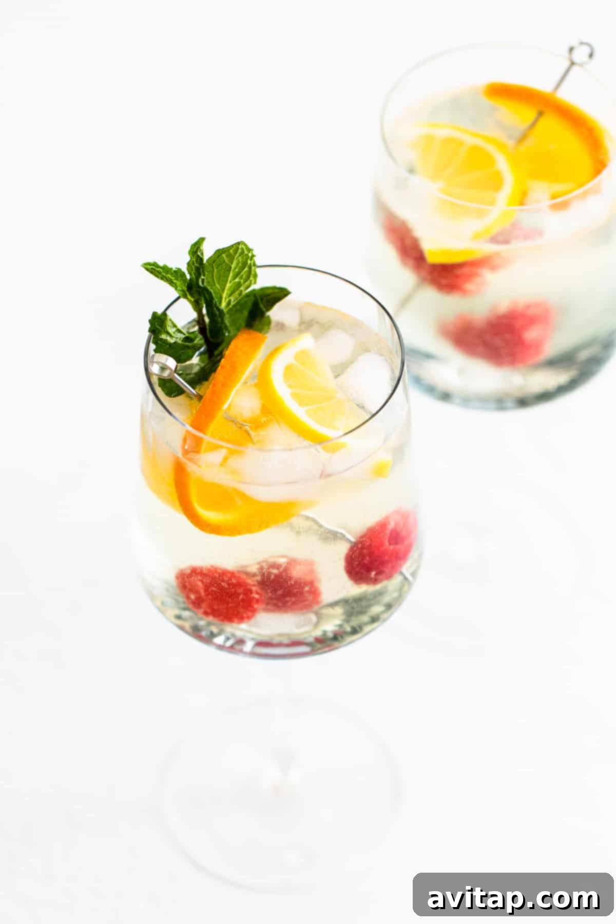 Refreshing White Wine Spritzer in a wine glass with citrus and berries, ready to be enjoyed.