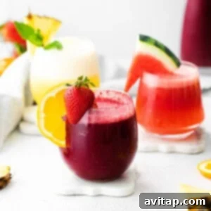 Three wine slushies in glasses, garnished with fruit, perfect for a hot day.
