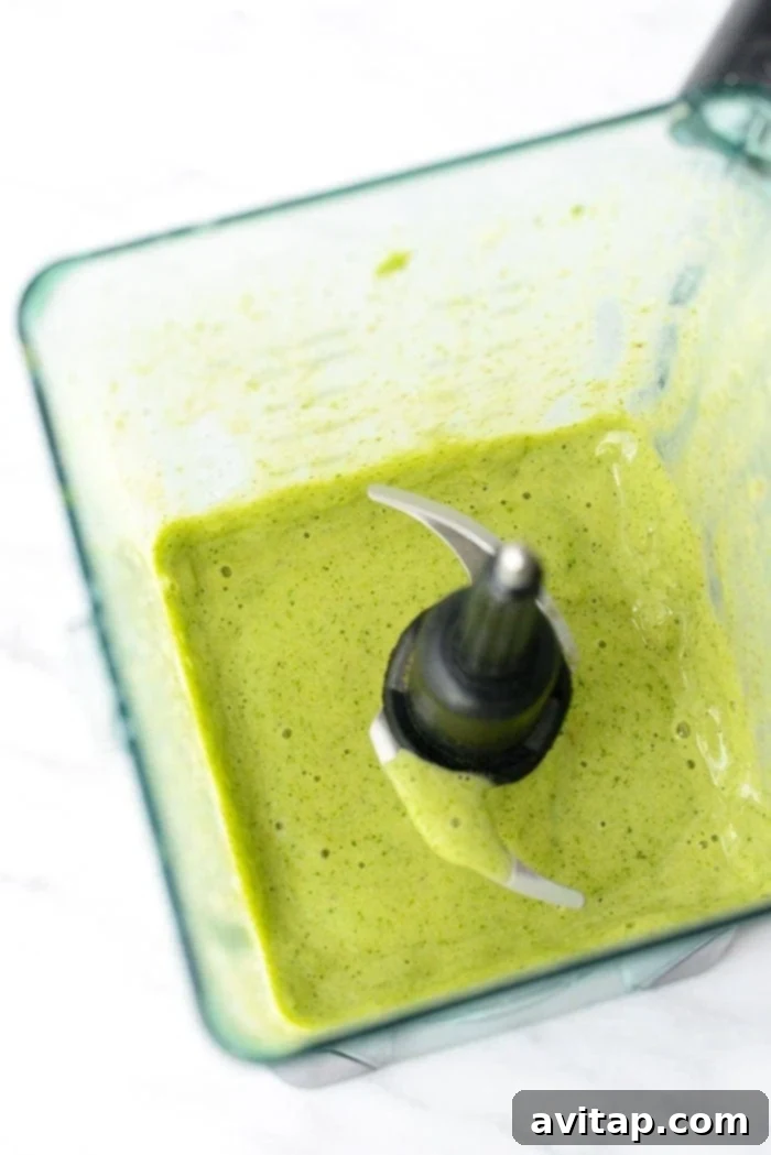 Close-up of a vibrant green Healthy Shamrock Shake being blended in a high-speed blender, showcasing the creamy texture and natural color.