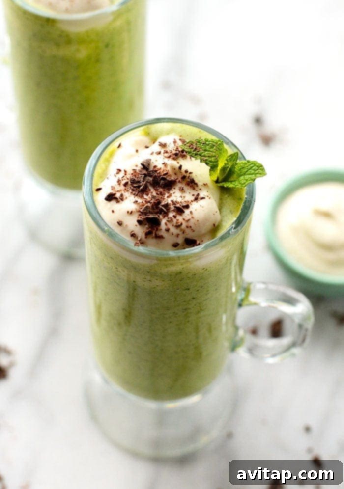 A perfectly blended Healthy Shamrock Shake served in a clear glass, showing its smooth, vibrant green texture. It's ready to be enjoyed.