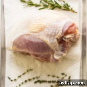 A rinsed turkey breast on a paper towel, being patted dry before seasoning.