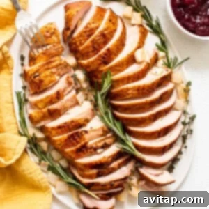 Smoked turkey breast, perfectly cooked and sliced on a wooden plate, ready for serving.