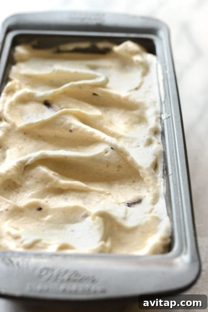 Close-up shot of creamy Peanut Butter Cup Banana Nice Cream in a bowl, showing flecks of peanut butter cups.