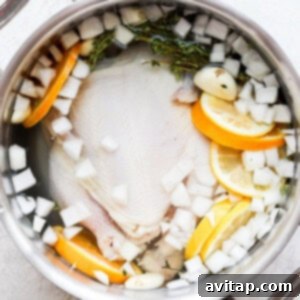 A large pot filled with the prepared chicken brine, infused with citrus and herbs.