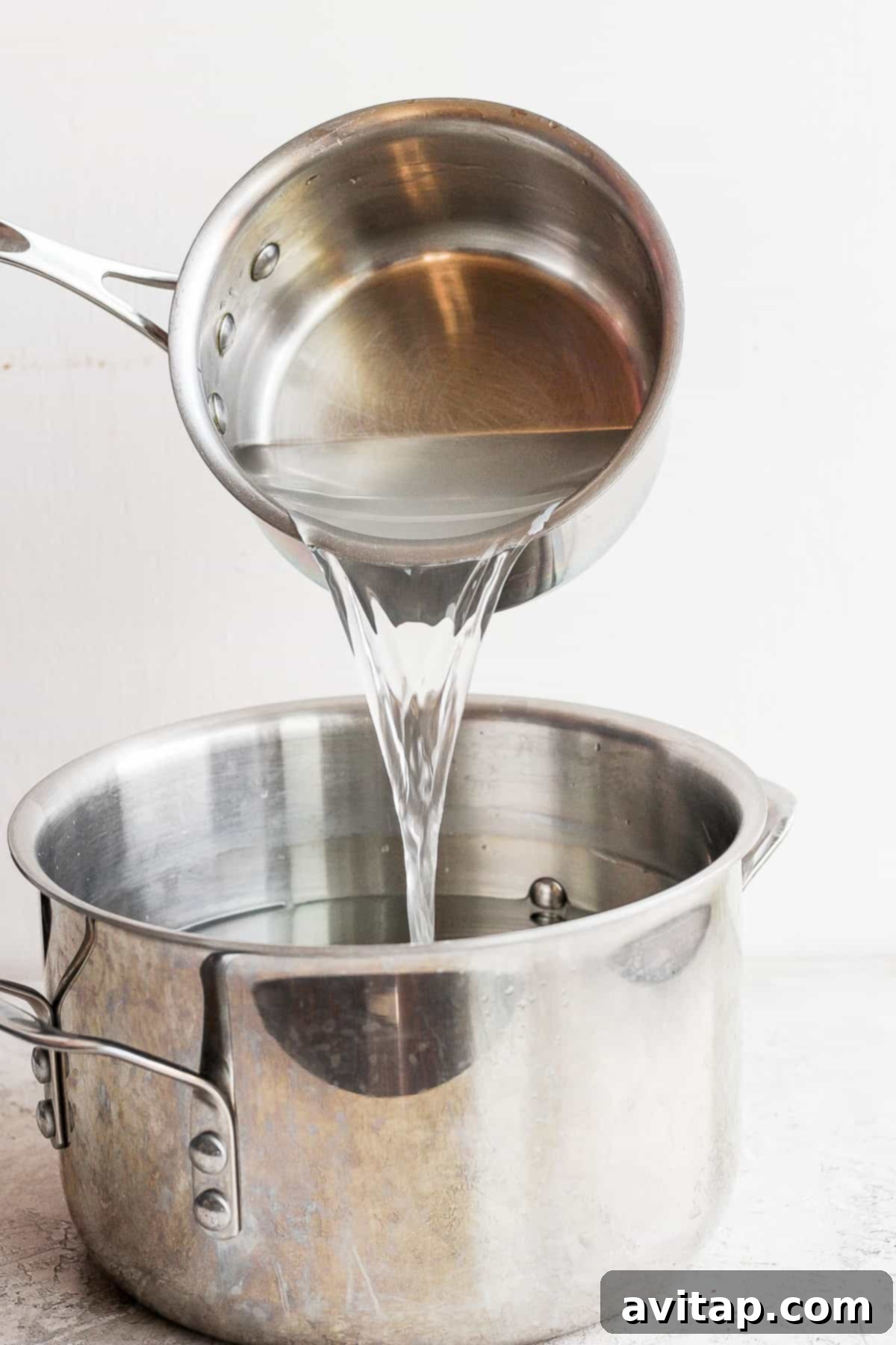 Carefully pouring the prepared chicken brine over the whole chicken in a large pot.
