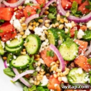 A close-up of the finished watermelon salad, garnished with pine nuts.