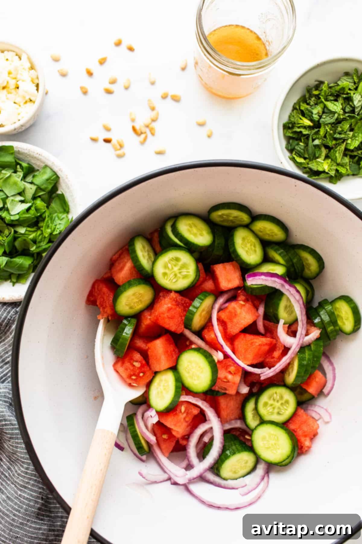 A large bowl of vibrant watermelon feta salad, ready to be served at a gathering.