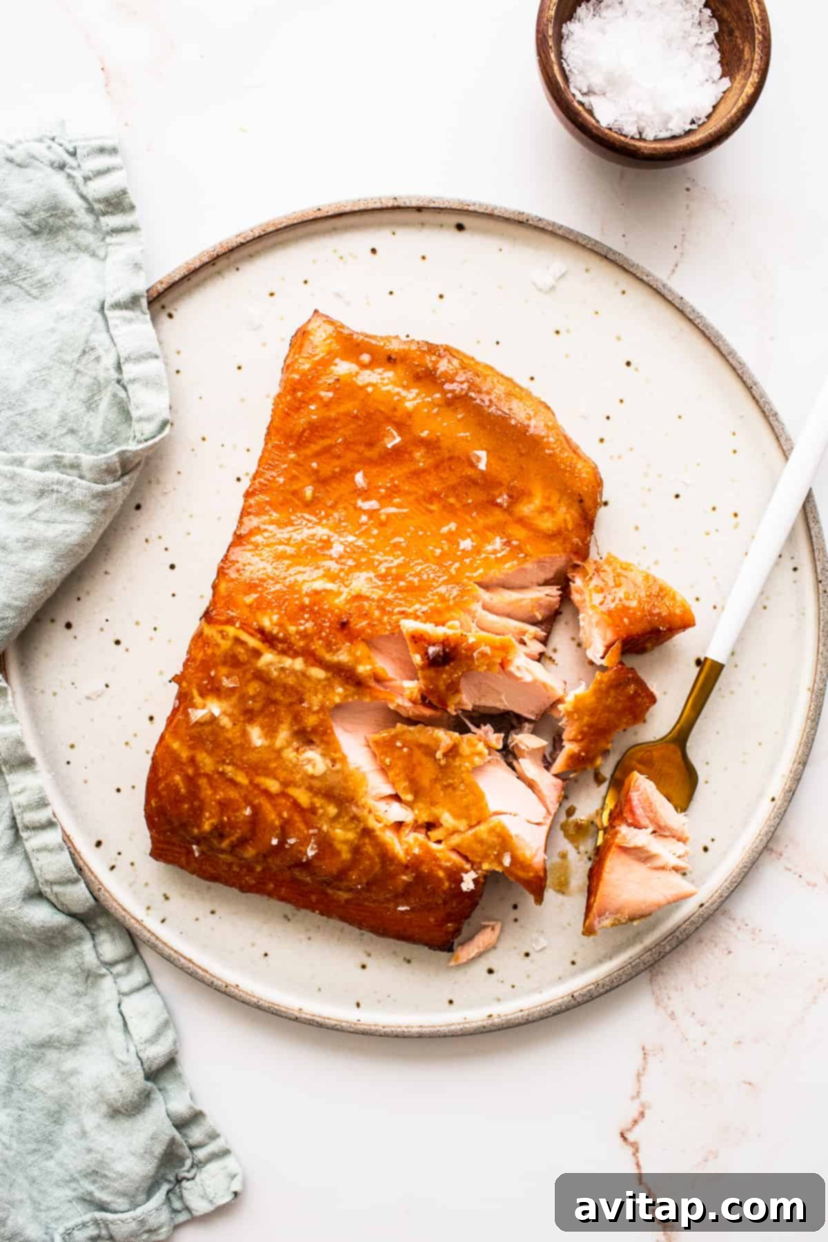 Perfectly smoked maple mustard salmon on a plate, ready to be enjoyed with a fork.