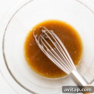 A close-up of the maple mustard smoked salmon marinade in a bowl, showing its smooth consistency.