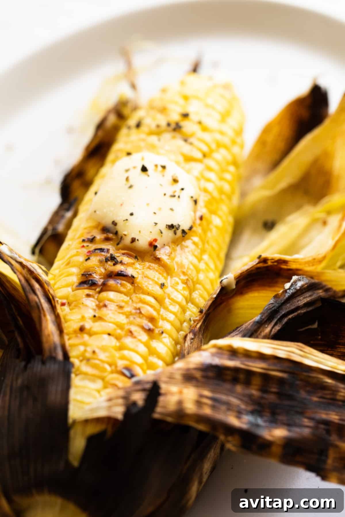 The Ultimate Grilled Corn Experience: Butter, Salt, Pepper Grilled corn on the cob, garnished with butter, salt, and pepper, presented beautifully.