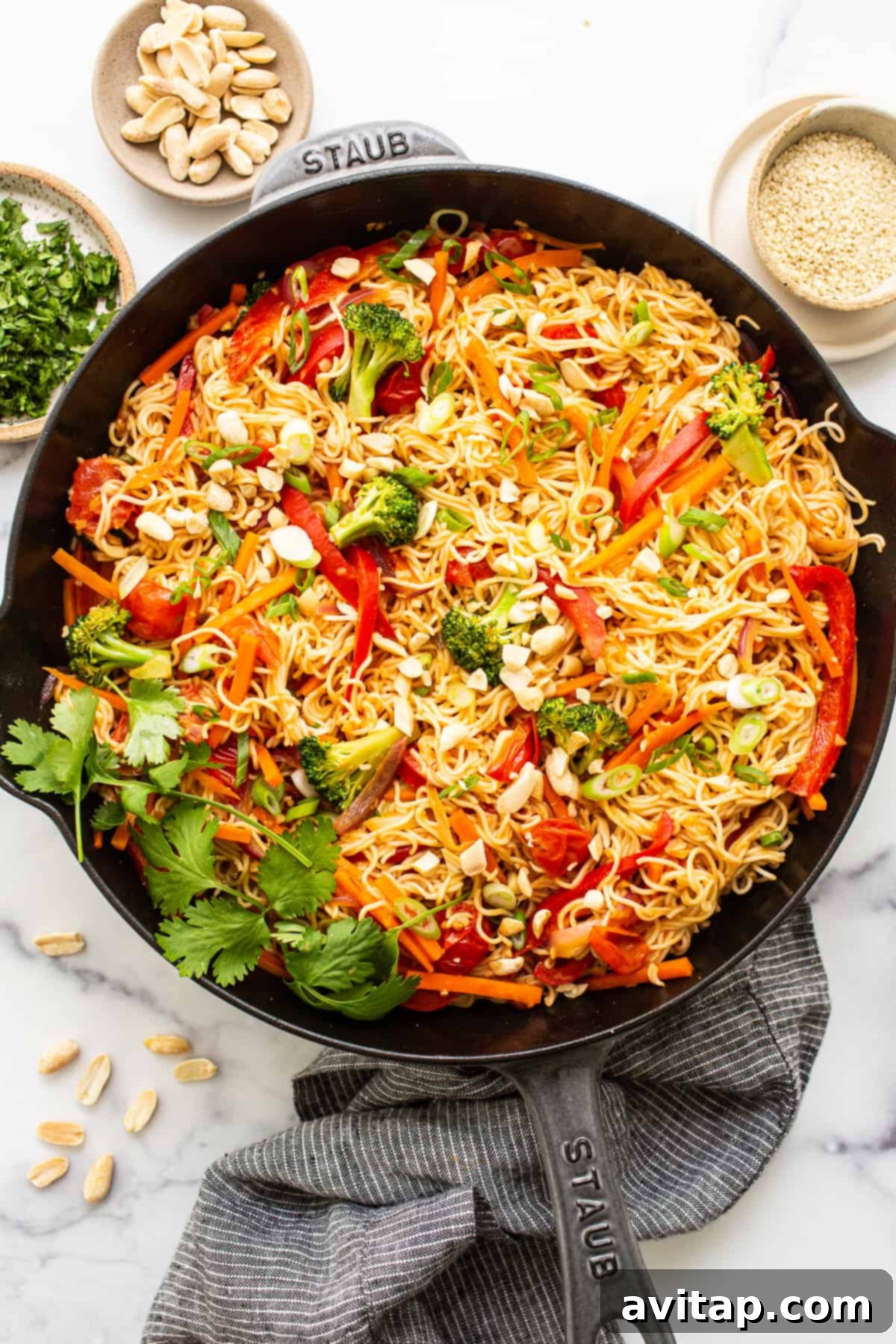 Peanut noodles beautifully plated in a cast iron skillet, showcasing a mix of colorful vegetables.