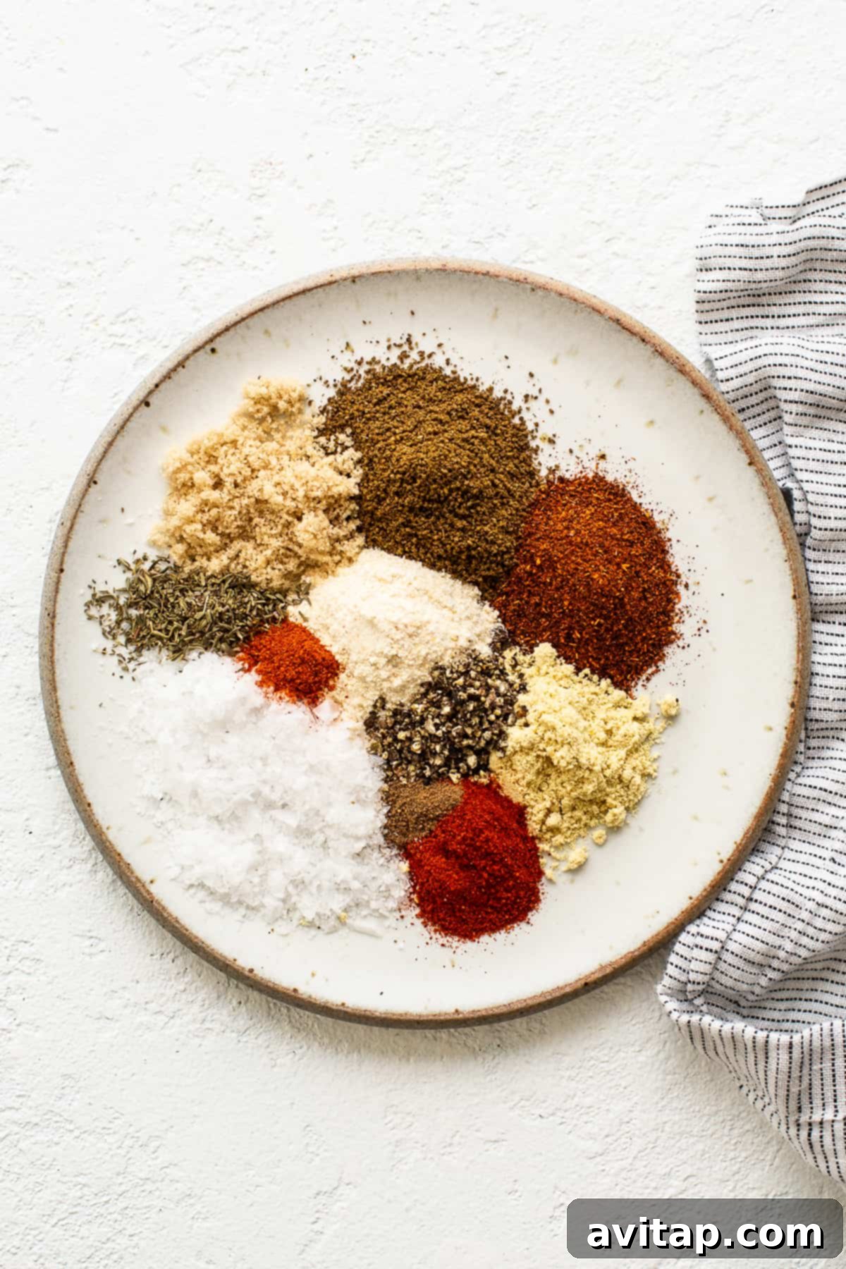 Assortment of spices on a plate with a kitchen towel, ready for blending.