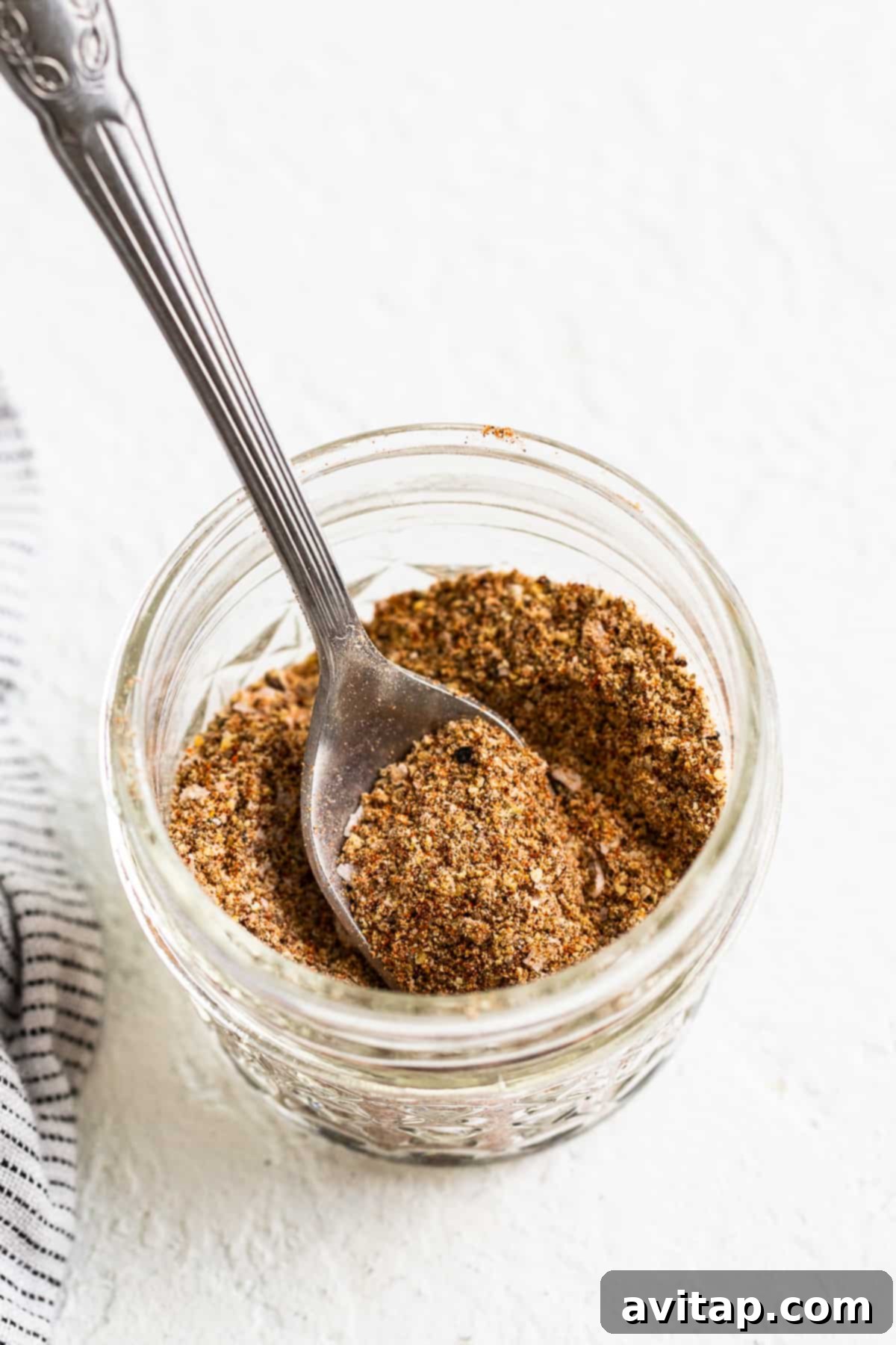 Homemade Old Bay Seasoning stored in a small Mason jar.