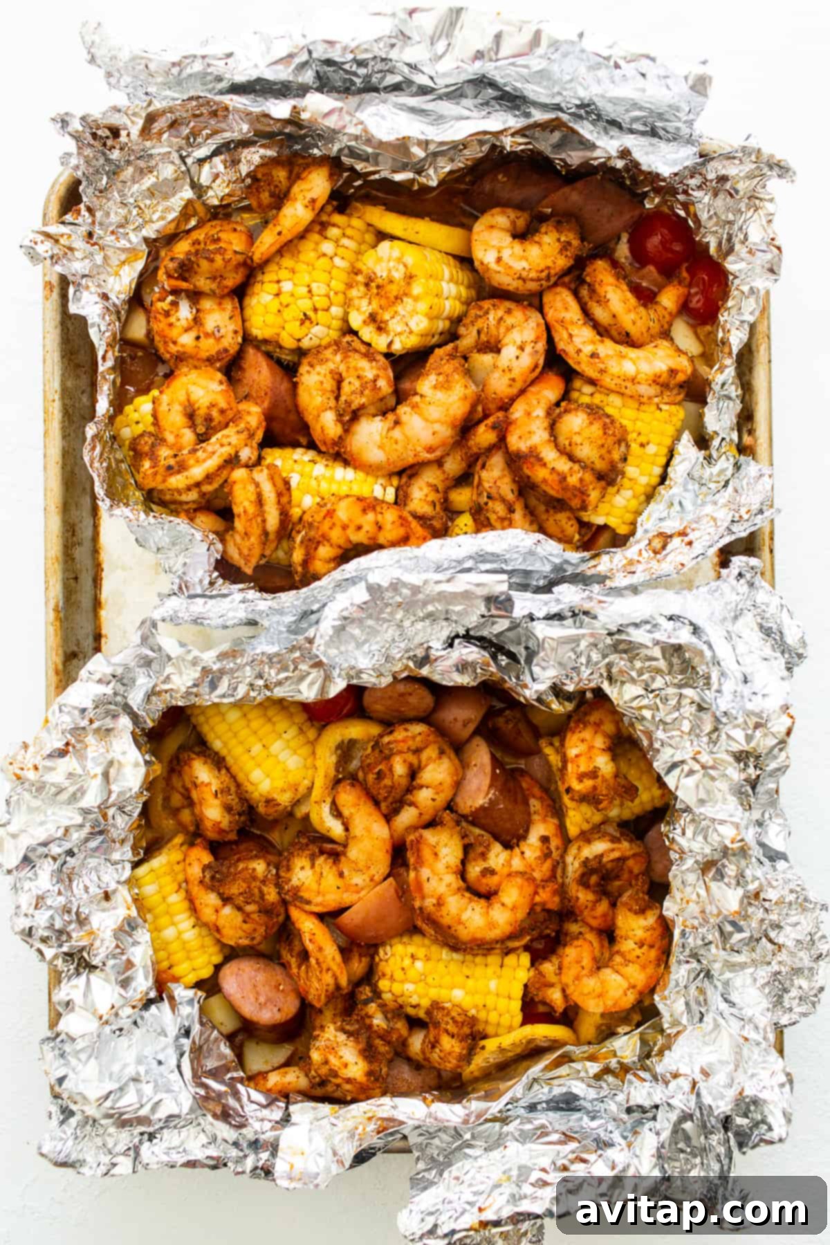 Easy Grilled Shrimp Parcels 6 All the vibrant ingredients for these shrimp packets, including shrimp, corn, potatoes, and sausage, are ready to go into two large foil packs.