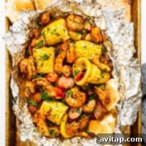 Grilled shrimp foil packets full of colorful veggies and succulent shrimp, ready to eat.