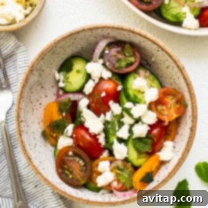 Vibrant Herb Cucumber Tomato Medley 10 A bowl of herby cucumber tomato salad, beautifully topped with crumbled feta cheese and ready for serving.