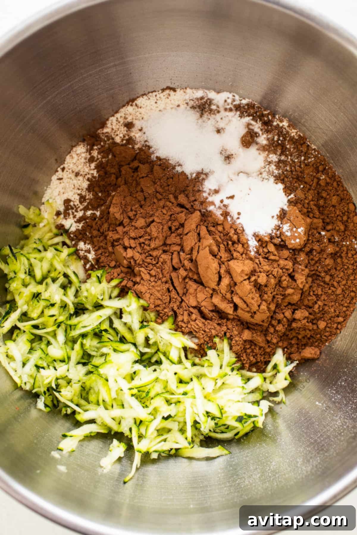 Dry ingredients for chocolate zucchini bread meticulously measured and gathered in a mixing bowl.