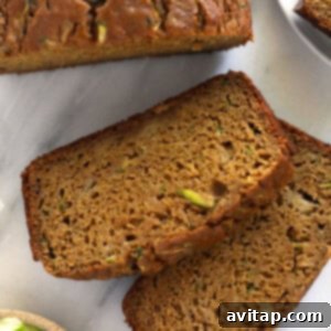 Golden-brown slices of classic zucchini bread arranged on a plate.