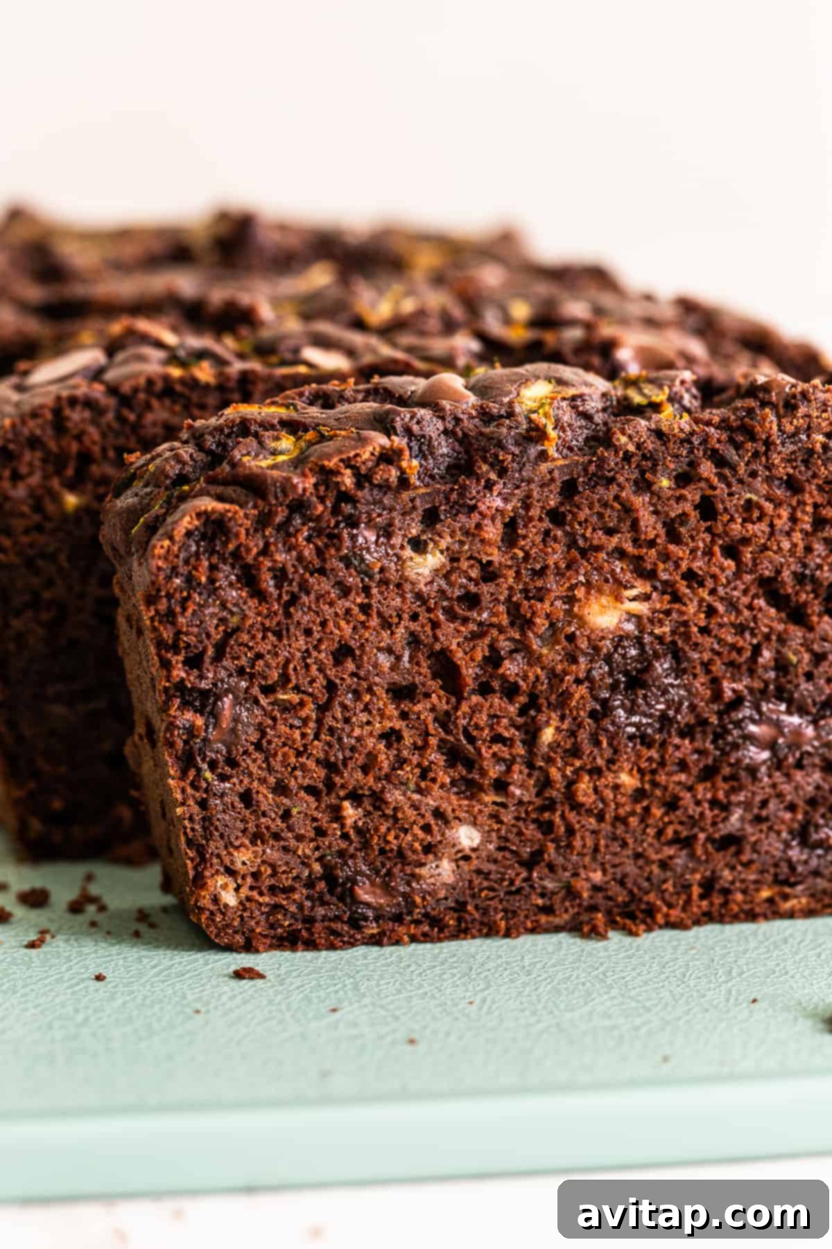 A perfectly baked slice of chocolate zucchini bread, revealing its moist interior and rich chocolate chips.
