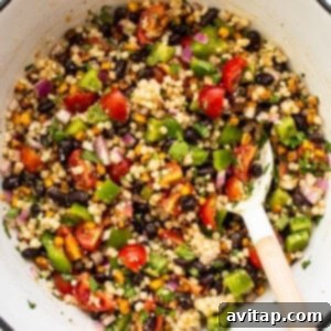 A bowl of fresh black bean couscous salad with a vibrant array of ingredients.