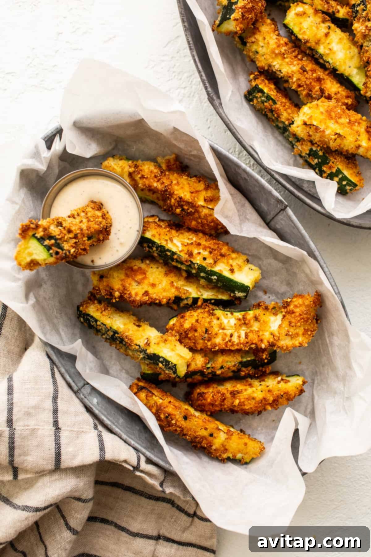 Crispy golden air fryer zucchini fries served in a woven basket.