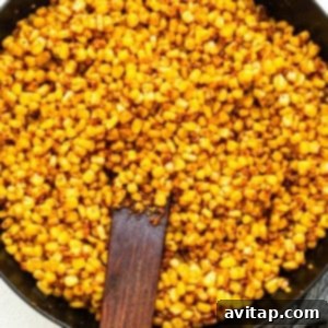 Fiesta Corn Pasta Salad 9 Corn kernels being pan-fried and seasoned in a cast iron skillet.