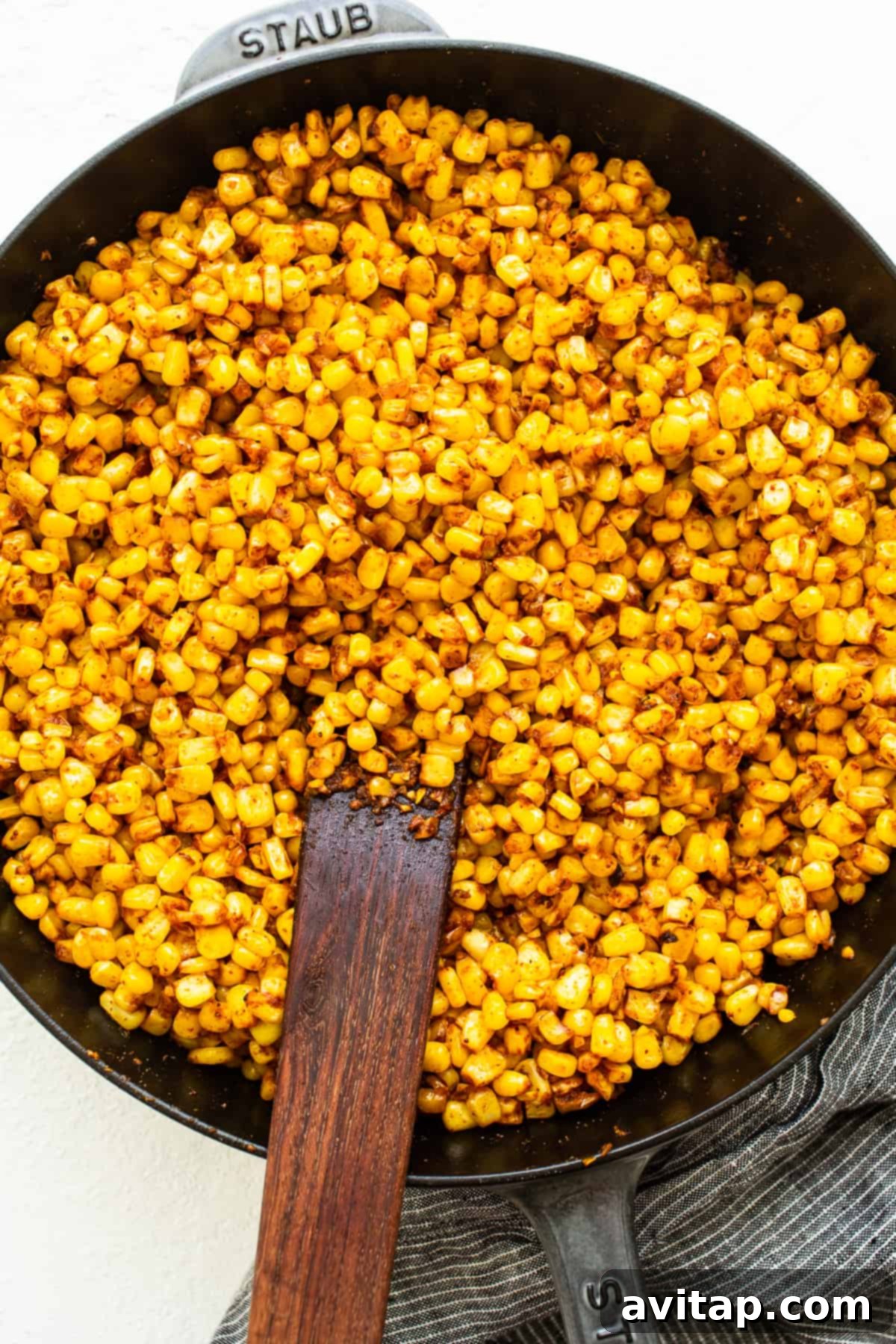 Fiesta Corn Pasta Salad 3 Sweet corn being pan-fried in a cast iron skillet with spices, turning golden brown.