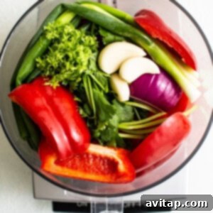 Fresh vegetables in a food processor, perfectly chopped and ready for the next step of making salsa.