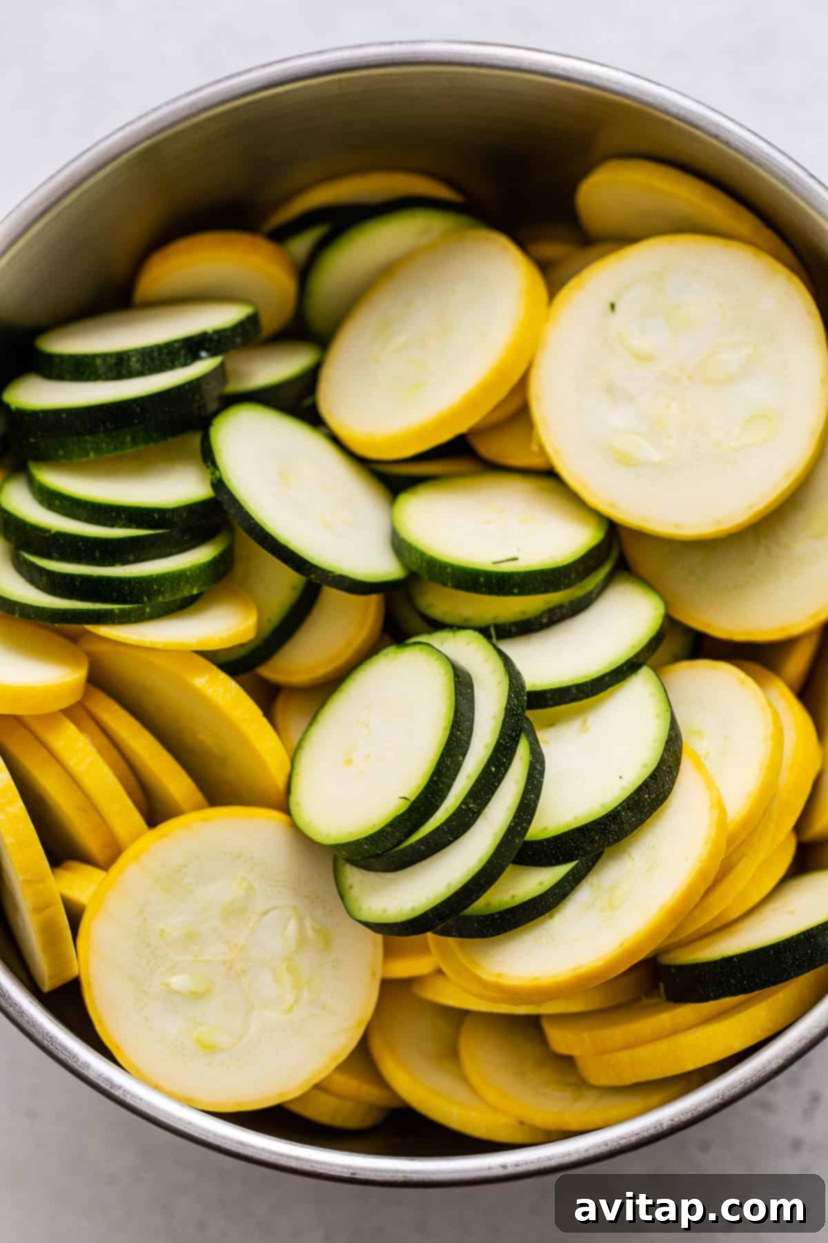 Expertly sliced squash and zucchini arranged in a bowl, ready for cooking.