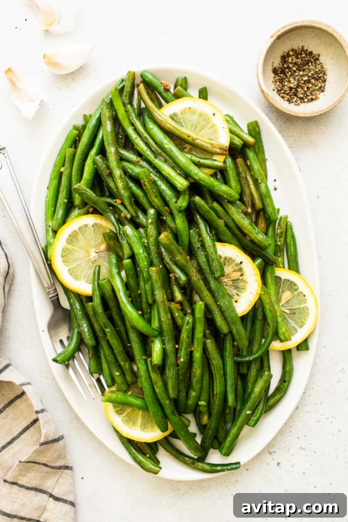 Perfectly cooked, vibrant green beans on a platter, ready to serve.