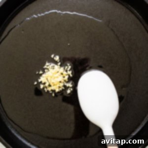 A frying pan with fragrant minced garlic sizzling in olive oil.